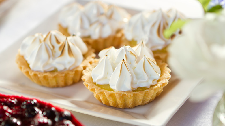 Small lemon tarts with baked meringue on top on a plate