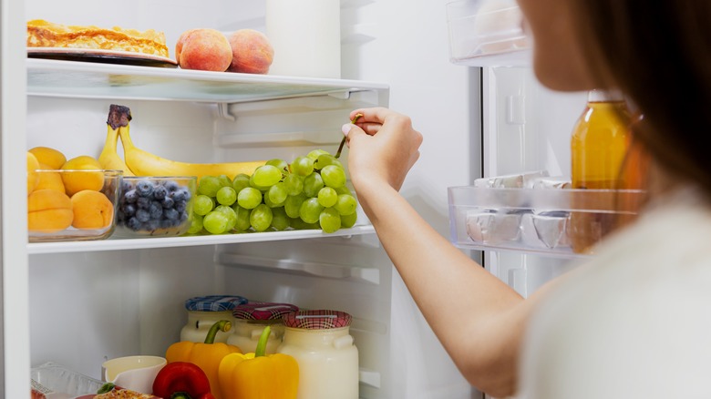 Person taking fruit from refrigerator