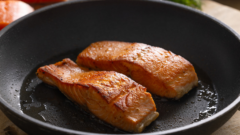 Two salmon fillets in a pan.
