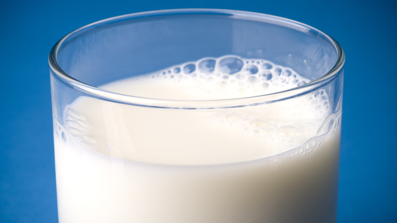 Glass of milk on blue background
