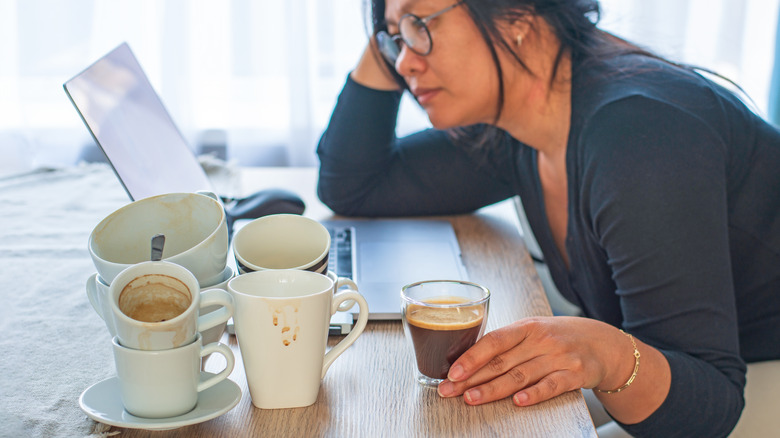 Woman feeling tired despite drinking several cups of coffee