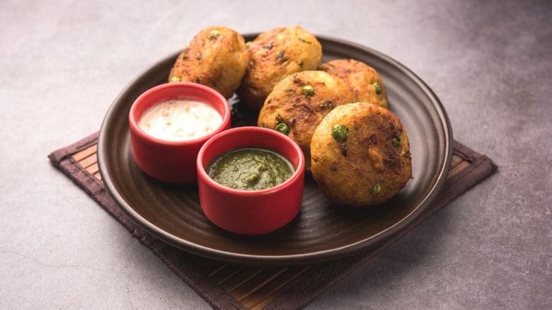 Plate of aloo tikki with chutneys.