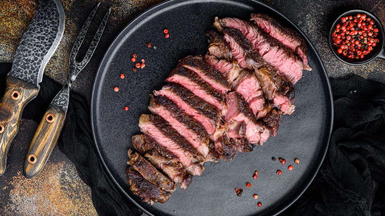Sliced steak on black plate