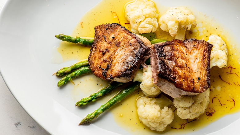halibut with asparagus and cauliflower on plate