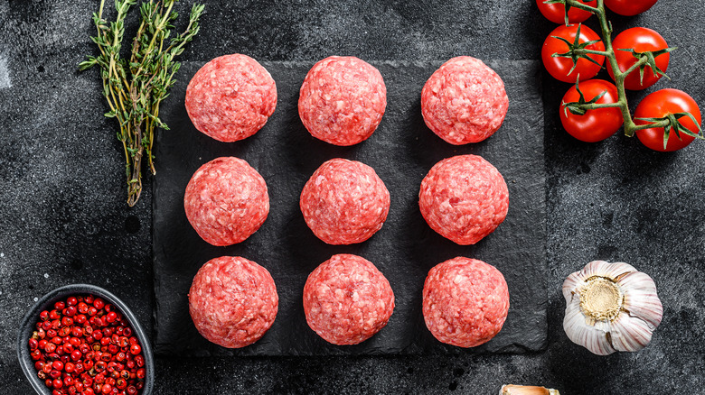Raw meatballs on black slate
