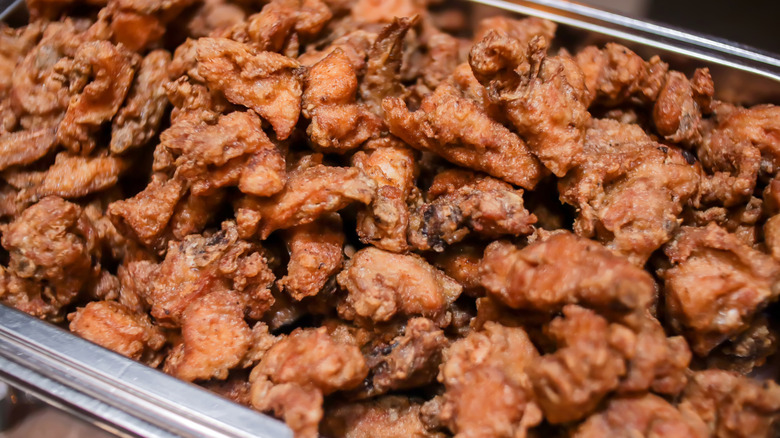 a big pile of fried chicken wings in a serving tray