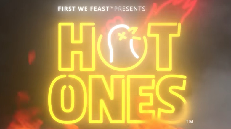 the fiery, smoky neon logo of Hot Ones, complete with a fire-breathing rooster in the O in hot