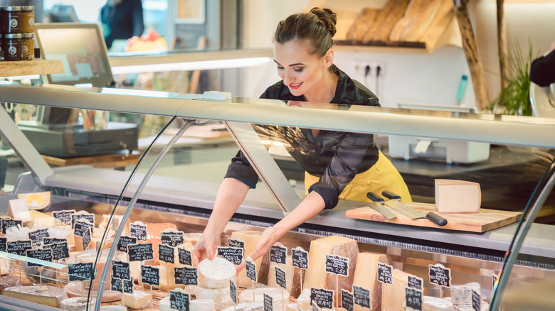 grocer stocking cheese case