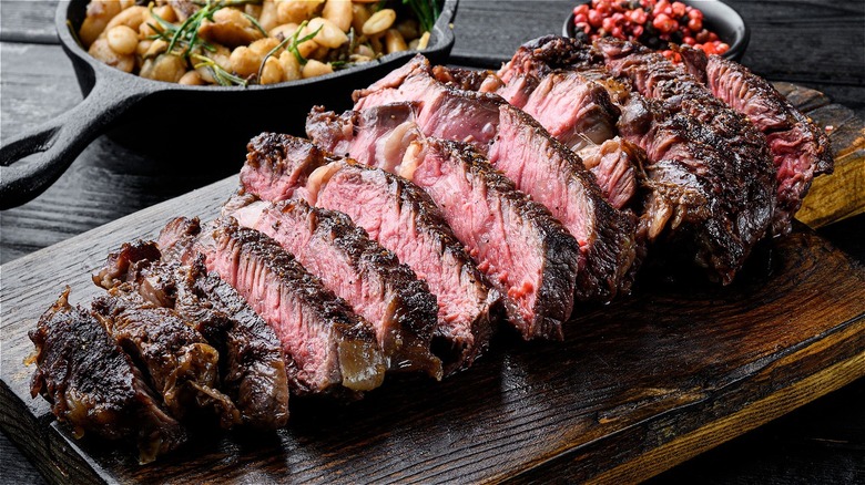 cooked steak sliced on a wooden plank 
