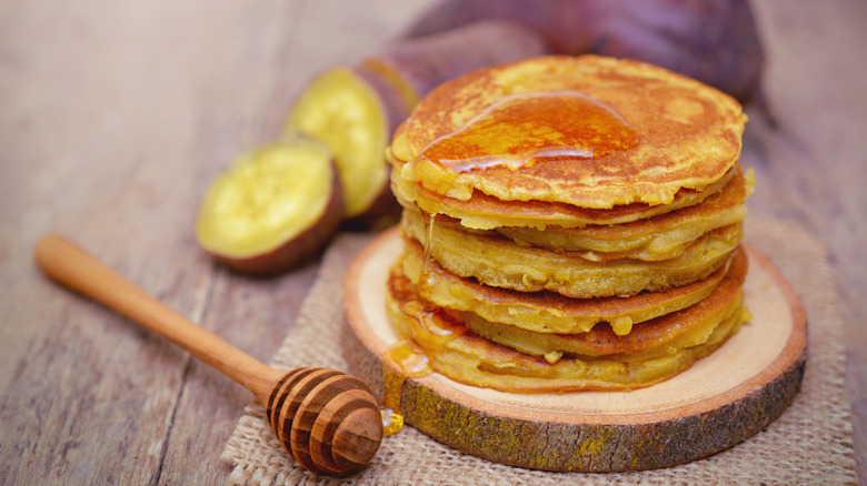 Stack of pancakes in front of sliced sweet potato