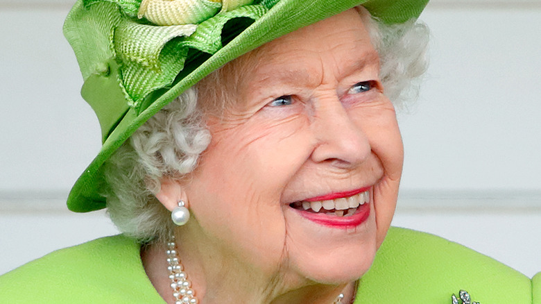 Queen Elizabeth II smiling and looking to the side