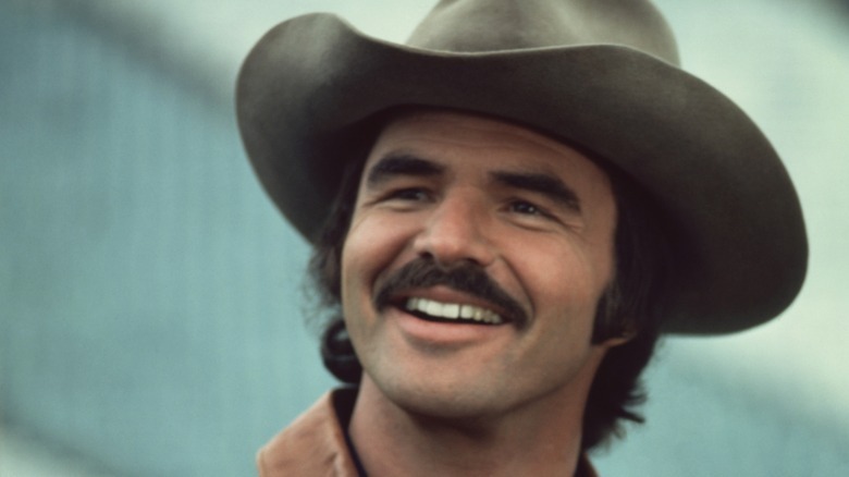 a young Burt Reynolds smiling and wearing a cowboy hat
