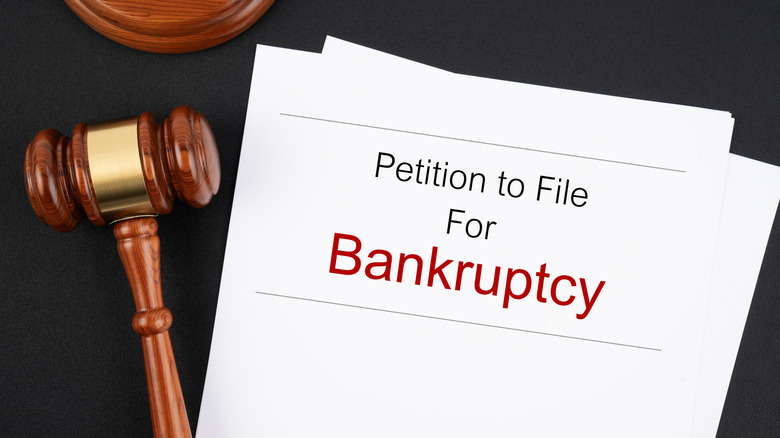 stock image of a judge's gavel and a stack of papers reading Petition to File For Bankruptcy
