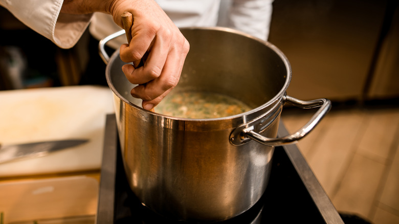 Chef stirring pot of soup