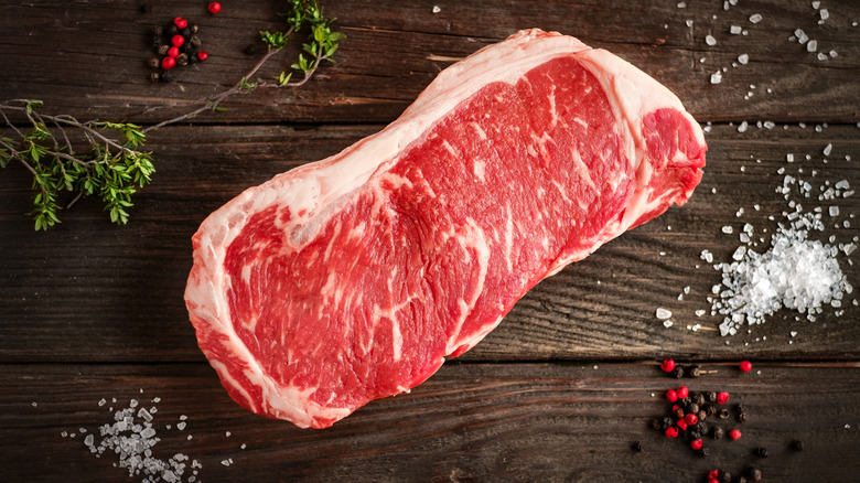 raw strip steak with seasoning