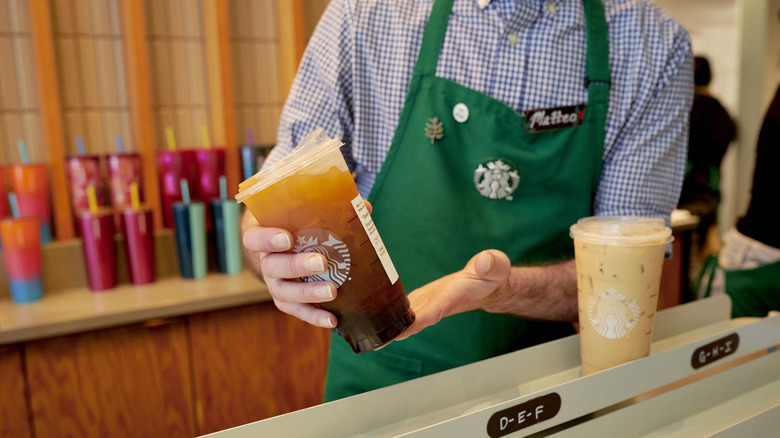 barista holding iced coffee