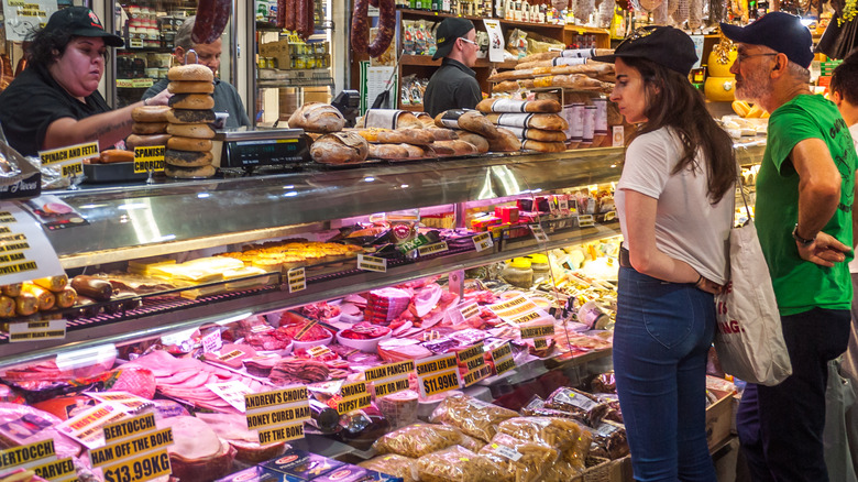 Customers choose meat at deli counter