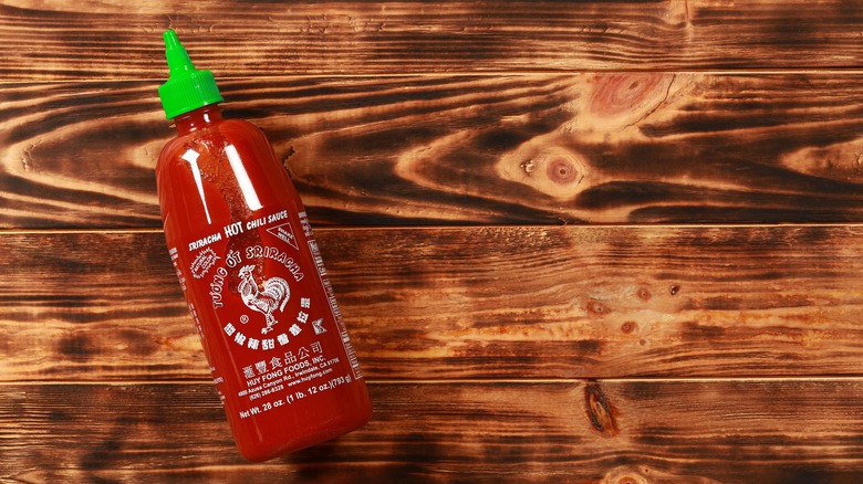 Sriracha bottle on wooden table
