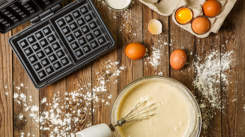 Waffle maker, eggs, and batter