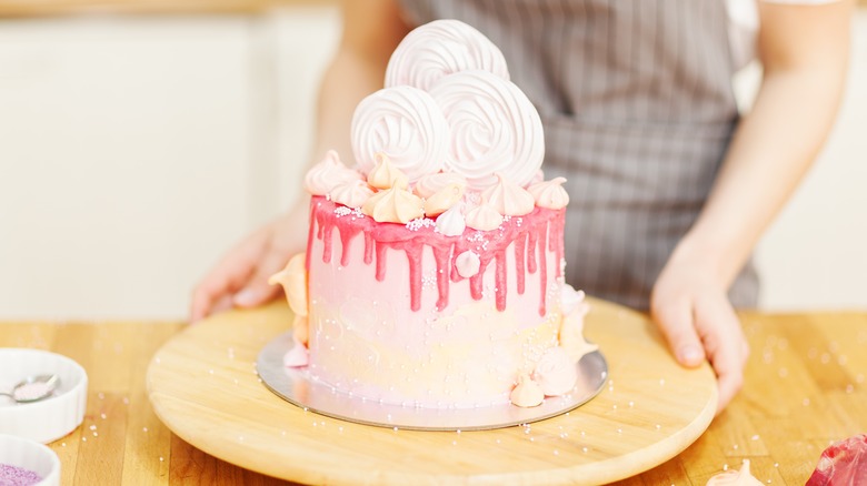 Person rotating cake on stand