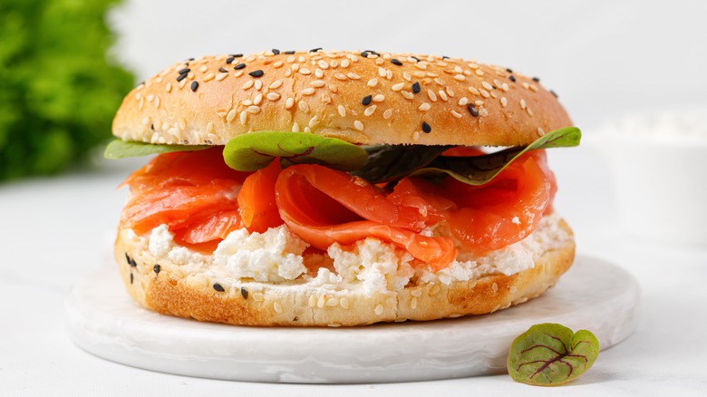 bagel with cream chees and lox on ceramic cutting board