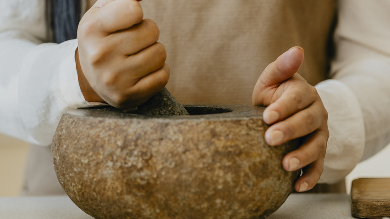 Individual grinding spices in a pestle and mortar
