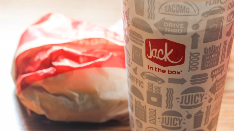 jack in the box drink cup in front of wrapped sandwich