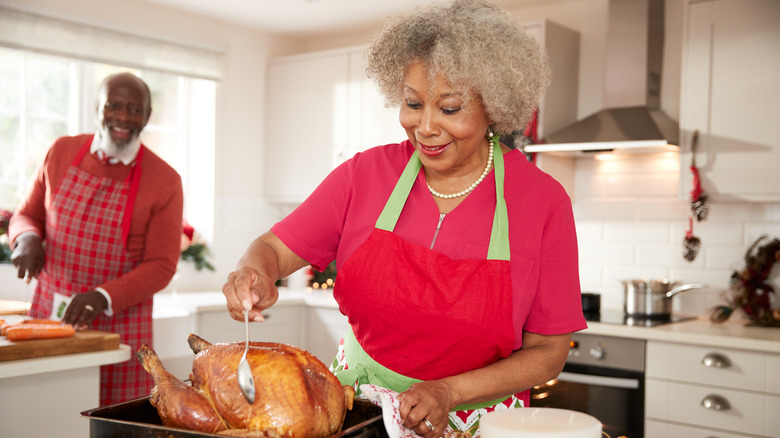 A woman basting a turkey