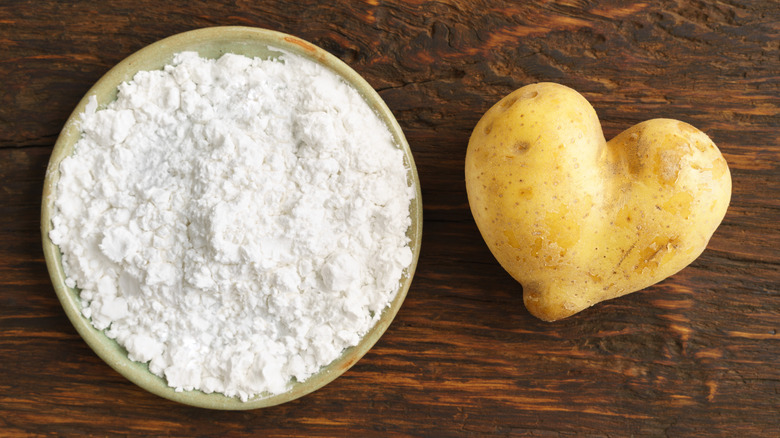 Potato flour next to a raw potato 