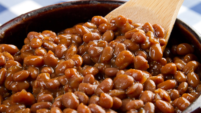 Cooked beans in a dish with wooden spatula