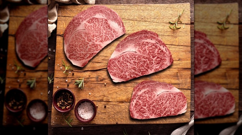 Three Costco wagyu steaks on cutting board with salt and pepper