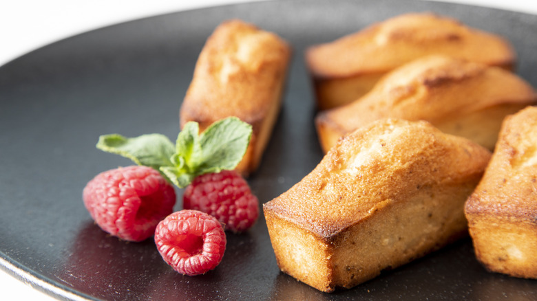 A plate of financier cakes and raspberries