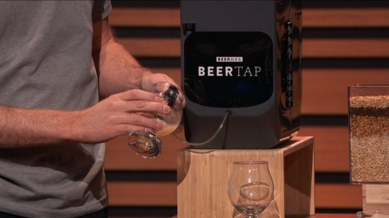 Aaron Walls filling glass with beer brewed by the BEERMKR
