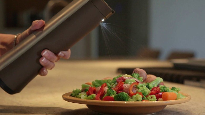 Biem spraying butter on vegetables