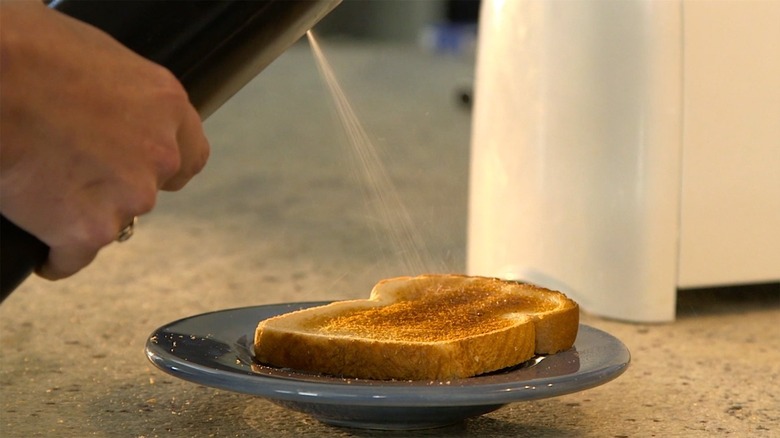 Biem spraying butter on toast