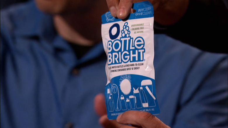 A pair of hands holding a package of Bottle Bright