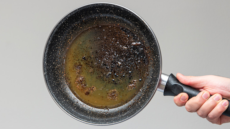 hand holding greasy frying pan