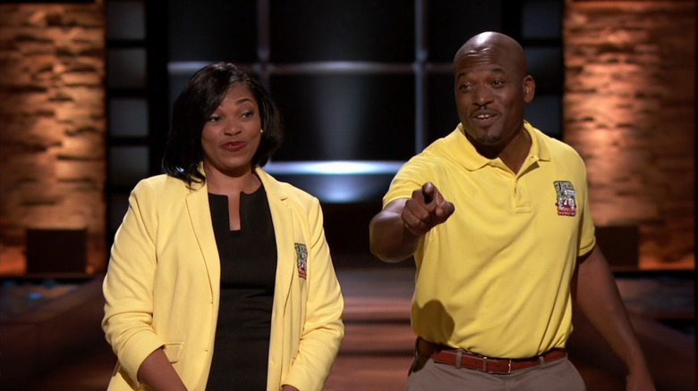 Joe Dowell pointing at the Sharks and smiling as Maranda Dowell looks on