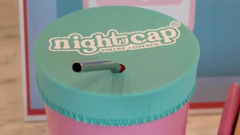 NightCap cover on a glass with a straw