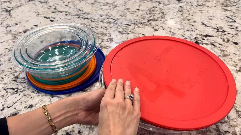 Woman closing the lid of a Pyrex set