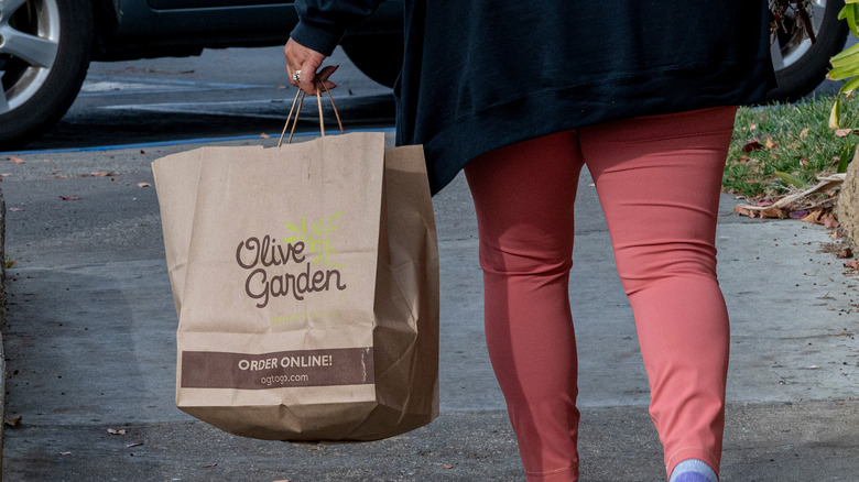 customer walking away holding olive garden bag