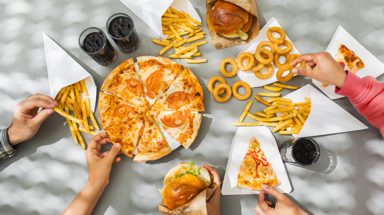 several kinds of fast food, including pizza, burgers, fries, and onion rings