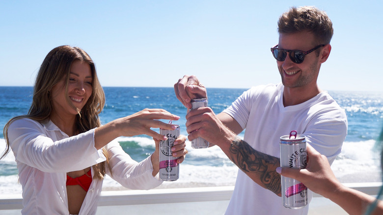 Two people crack open a White Claw
