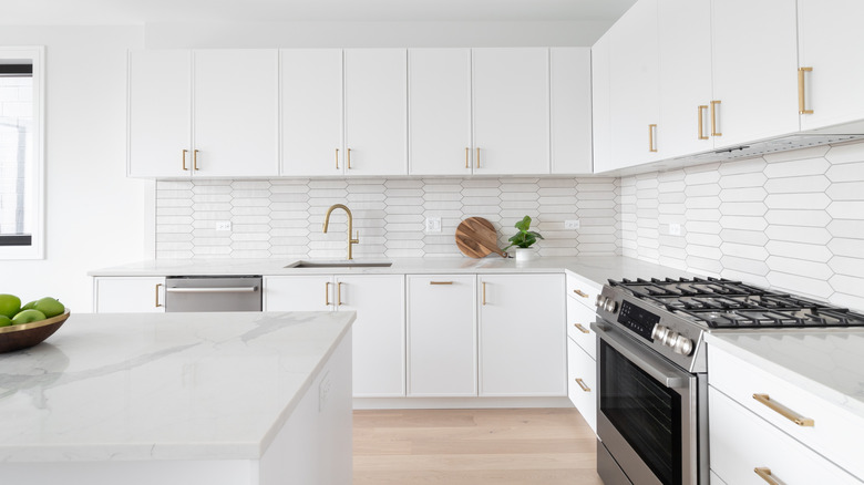 All white kitchen countertops and cabinets with gold accents