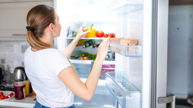Person placing produce in refrigerator