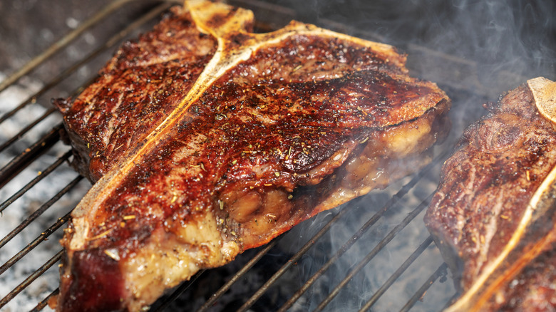 T-bone steak on a grill with a brown, caramelized crust.
