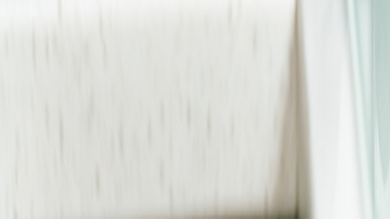 A large rice cooker plugged into the wall on a kitchen counter