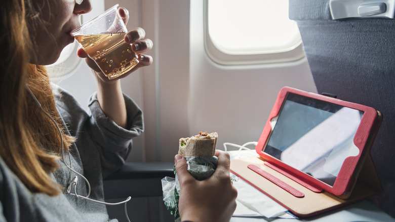 Woman drinking ginger ale on a plane