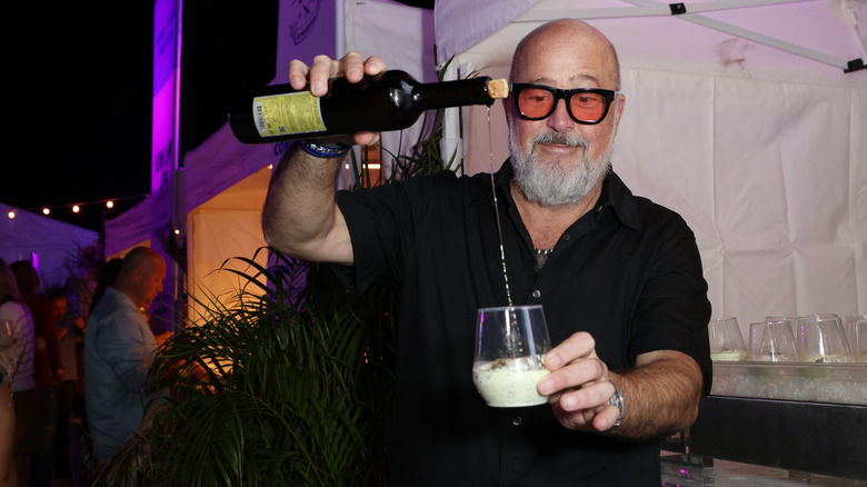 Andrew Zimmern pouring a drink