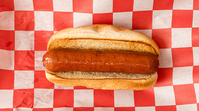 Hot dog in toasted bun on checkered paper